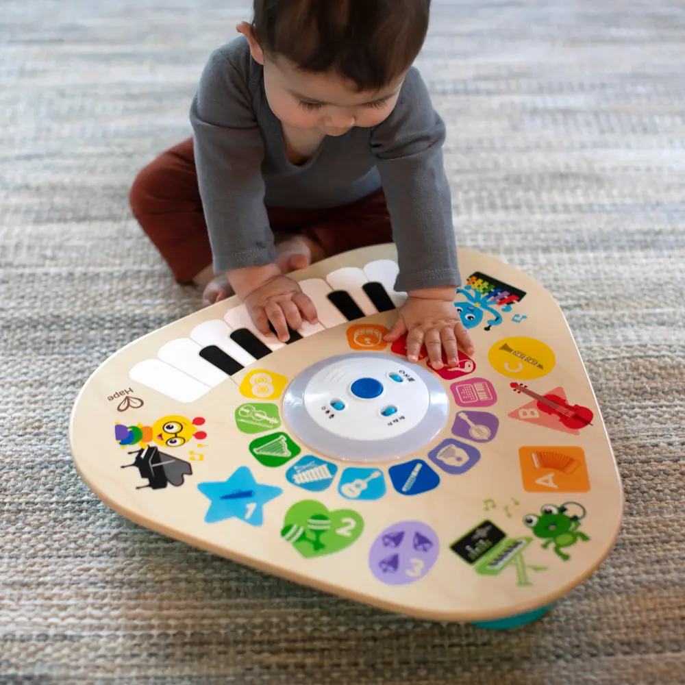 Малюк торкається деревʼяної поверхні музичного столика Baby Einstein Clever Composer Tune Table Magic Touch