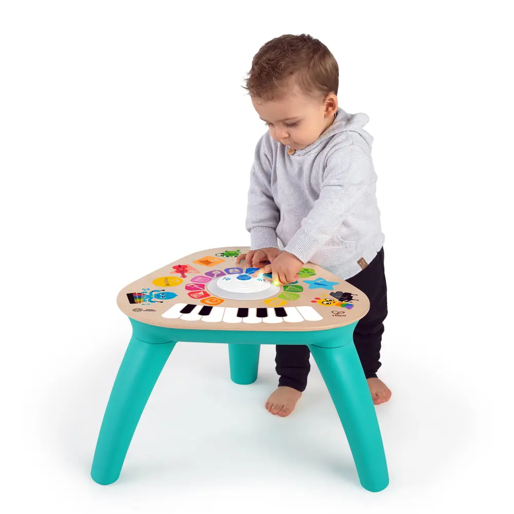 Малюк стоїть біля музичного столика Baby Einstein Clever Composer Tune Table Magic Touch