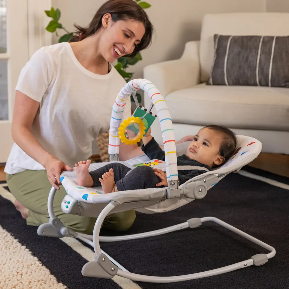 Мама заспокоює малюка в шезлонгу Baby Einstein Dean's Discovery Spot