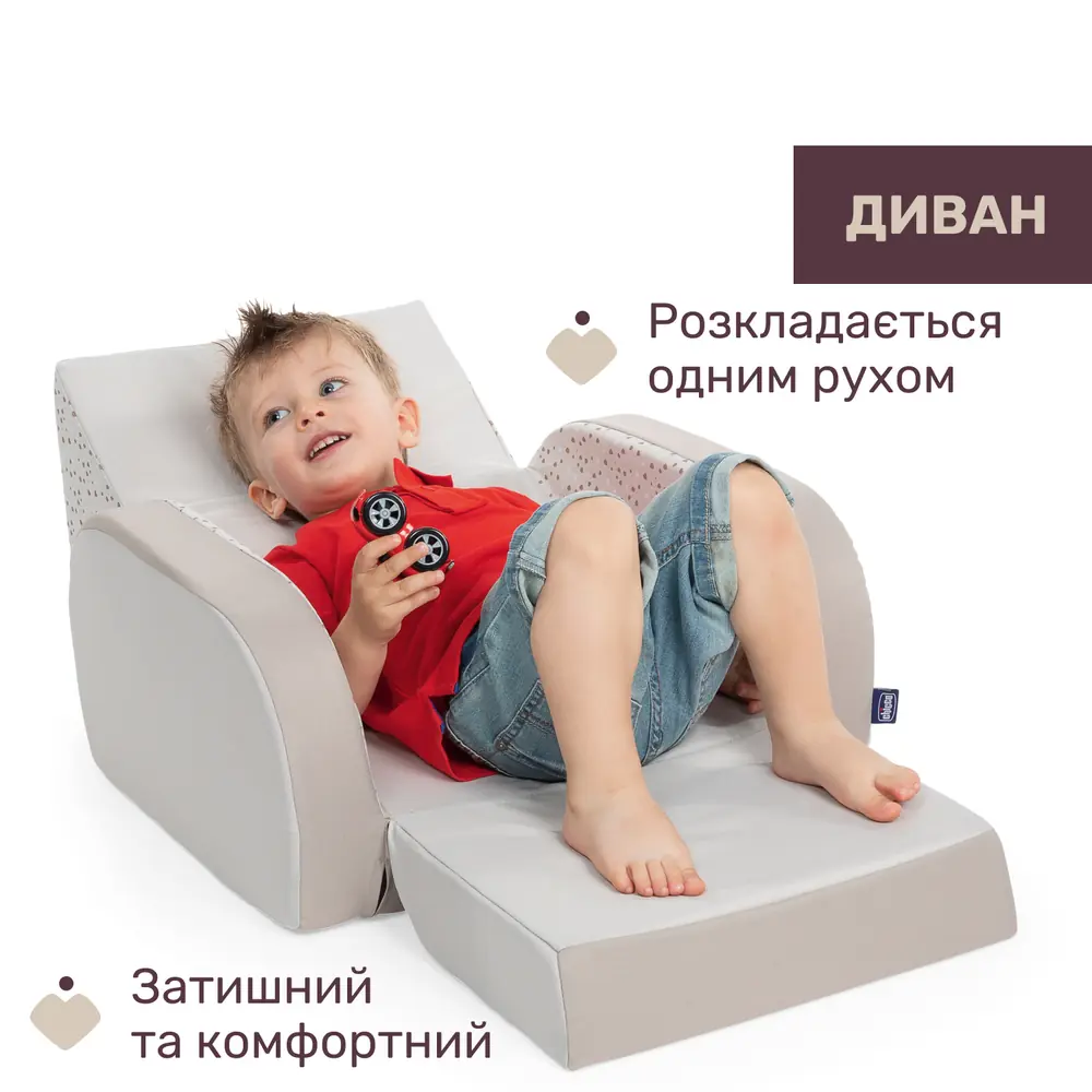 Хлопчик лежить у розкладеному дитячому кріслі Chicco Twist у конфігурації «Диван»