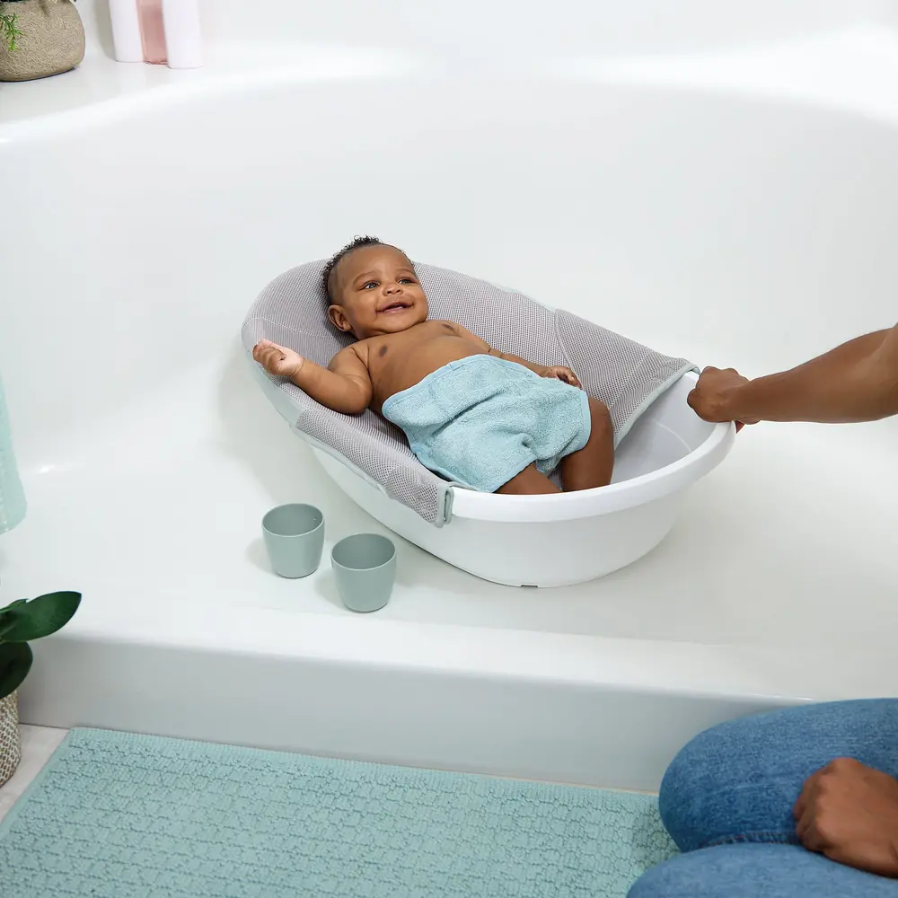 Малыш полулежит на регулируемом гамаке в ванночке Ingenuity Room to Soak