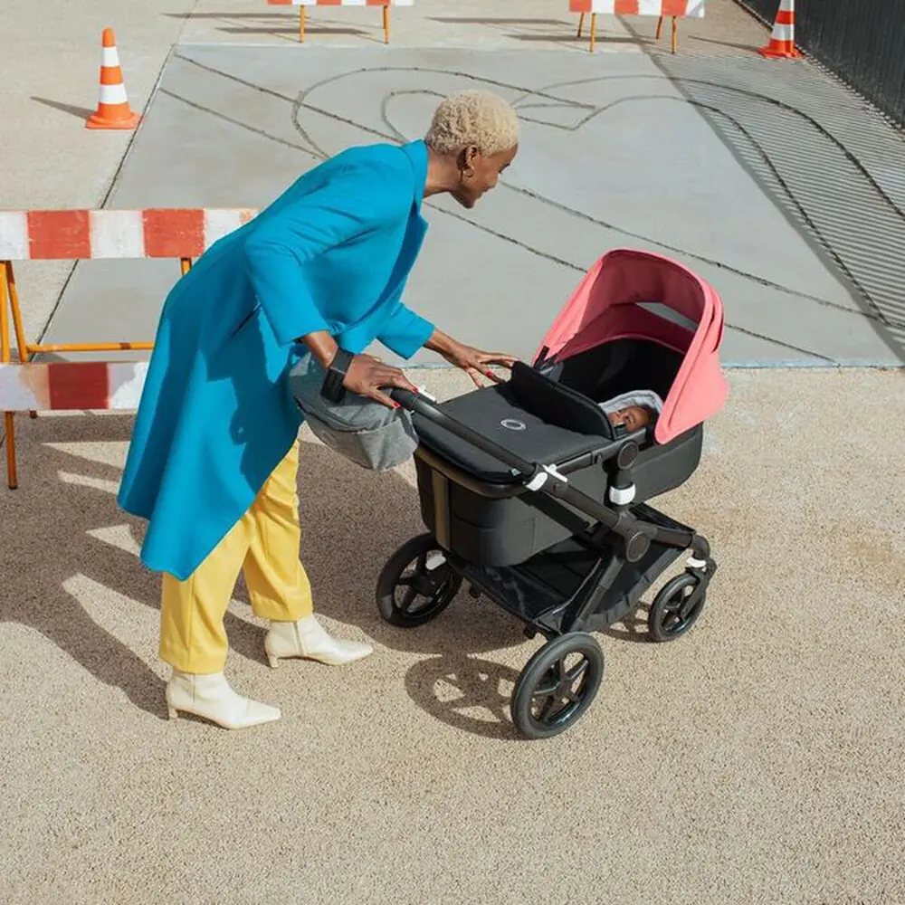 Мама наклоняется к люльке Bugaboo Fox 3