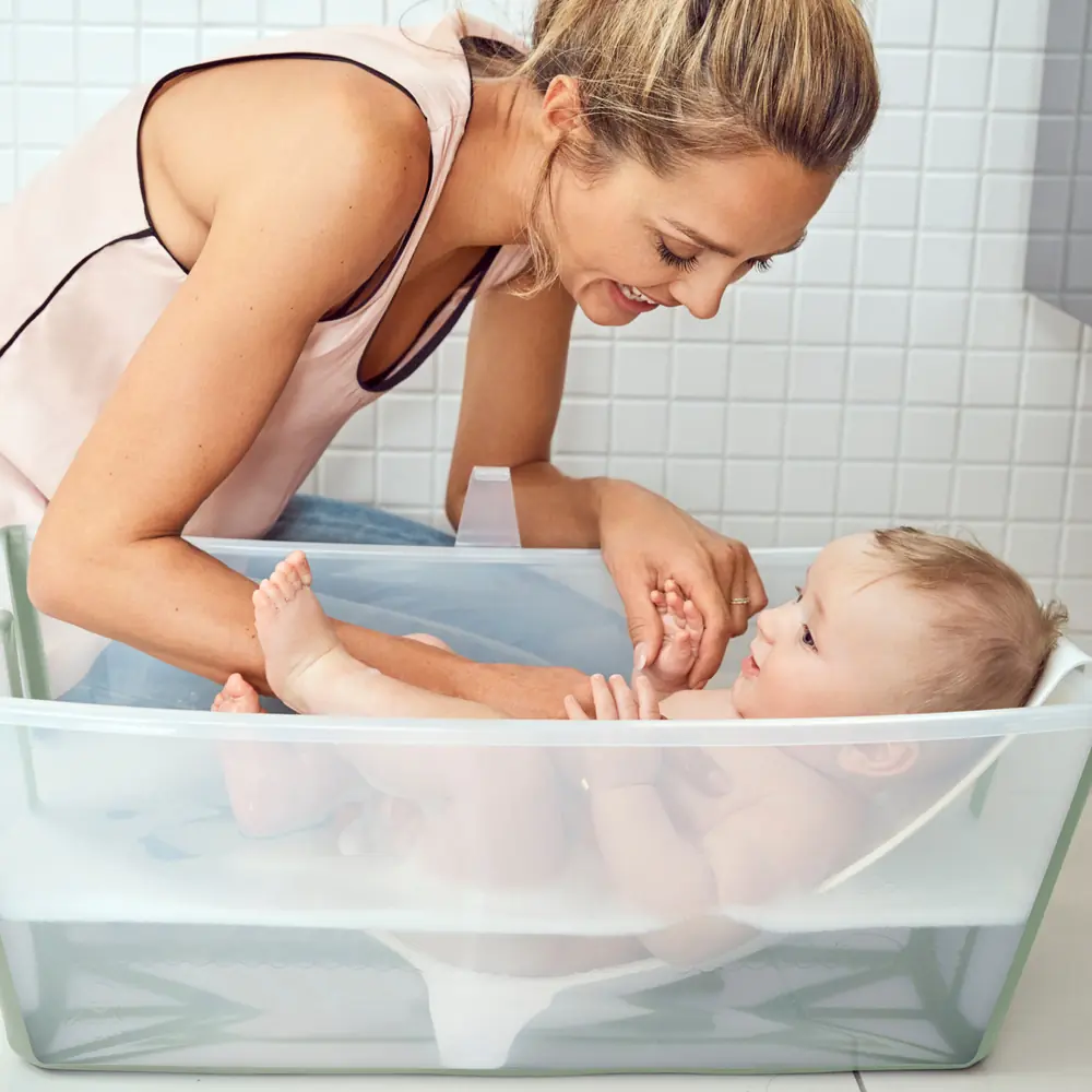 Мама купає немовля у ванночці Stokke Flexi Bath з адаптером для новонароджених