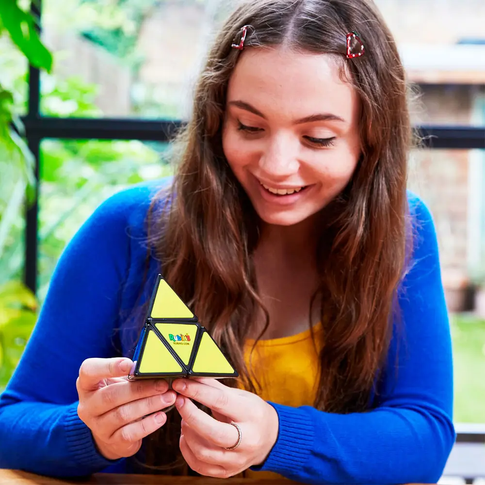 Дівчинка розглядає пірамідку Rubik's