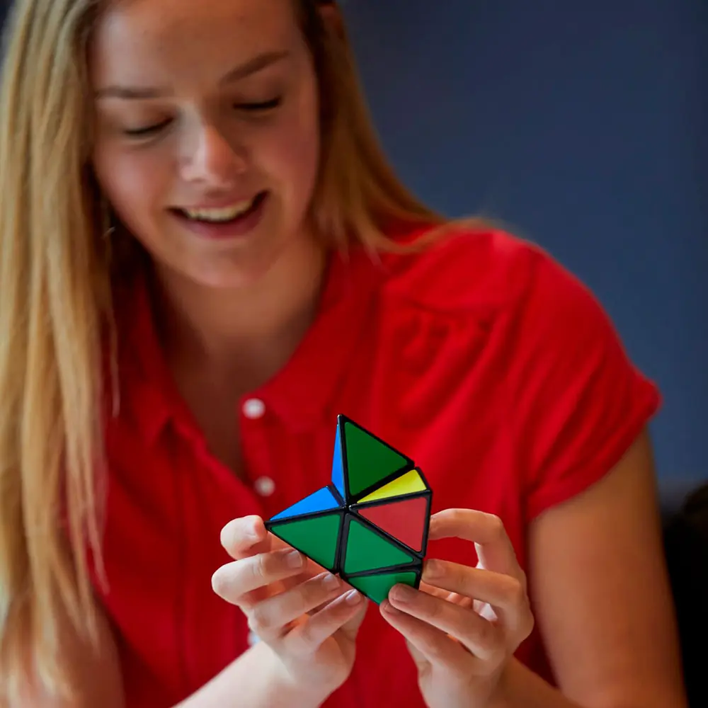 Дівчина тримає розфарбовану пірамідку Rubik's