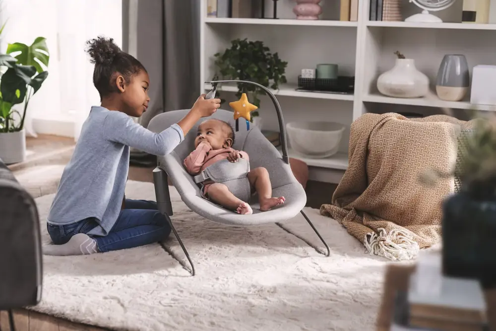 Девочка и малыш в шезлонге Kinderkraft Calmee Grey