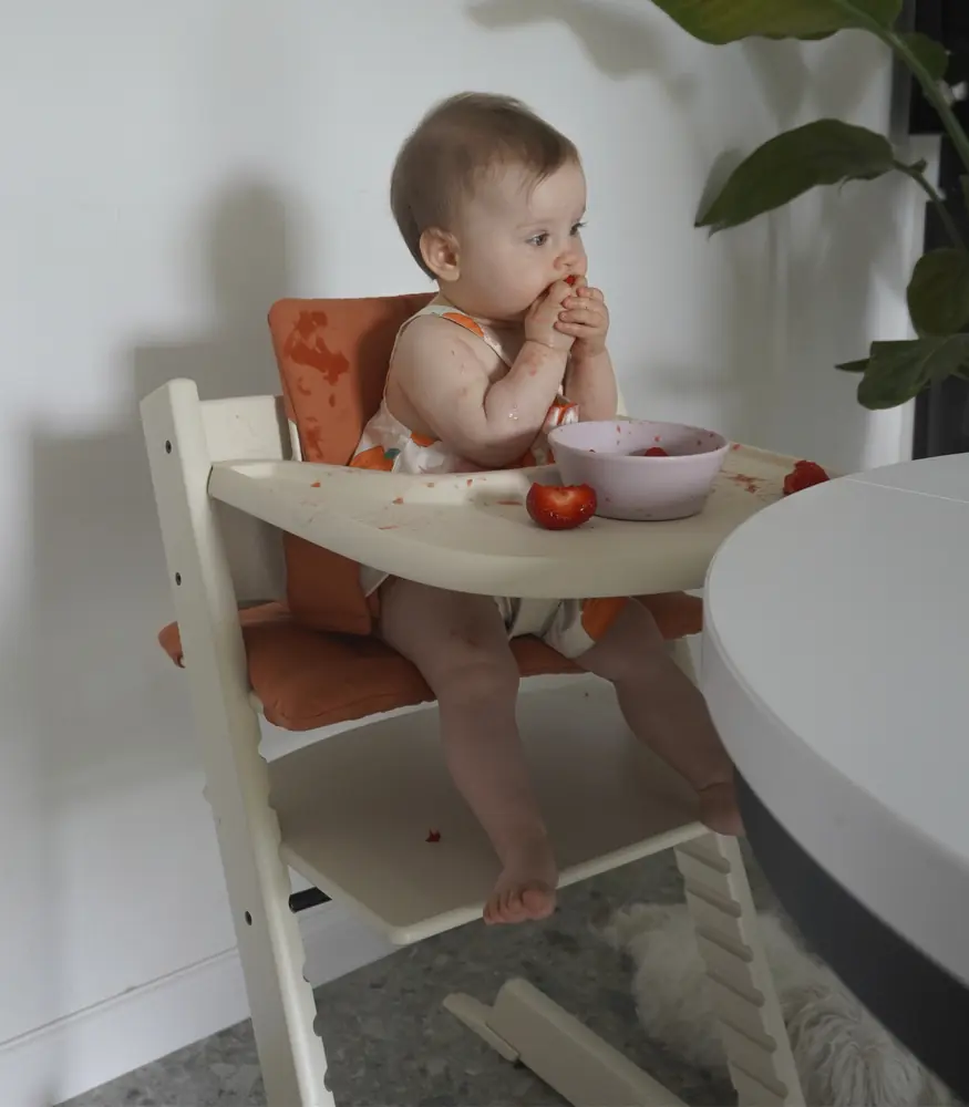 Малюк їсть за стільчиком Tripp Trapp зі стільницею Stokke Tray Vanilla White
