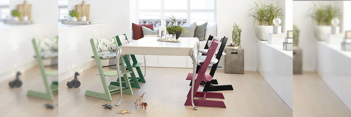 Стільчики Stokke Tripp Trapp різних кольорів біля обіднього столу