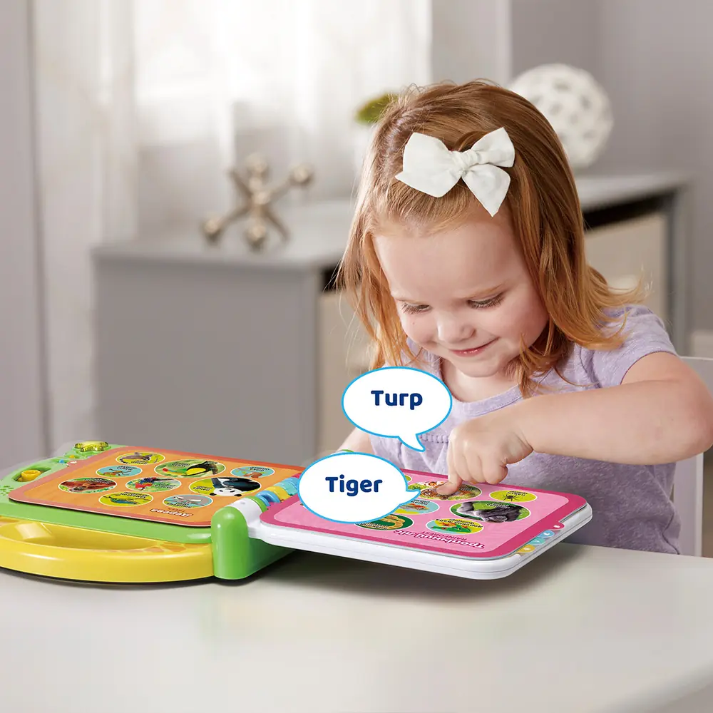 Дівчинка торкається сторінки розвивальної книги VTech